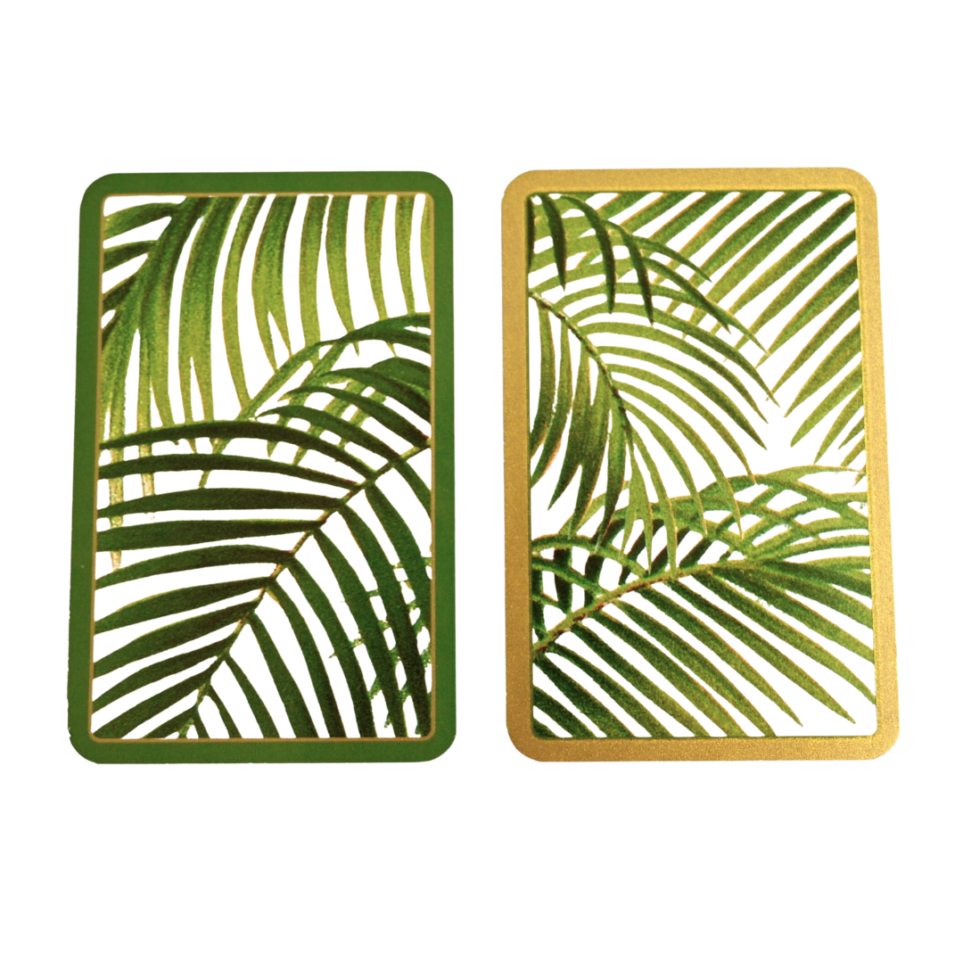 A twin pack of playing cards with green and gold palm leaf designs on the cards.