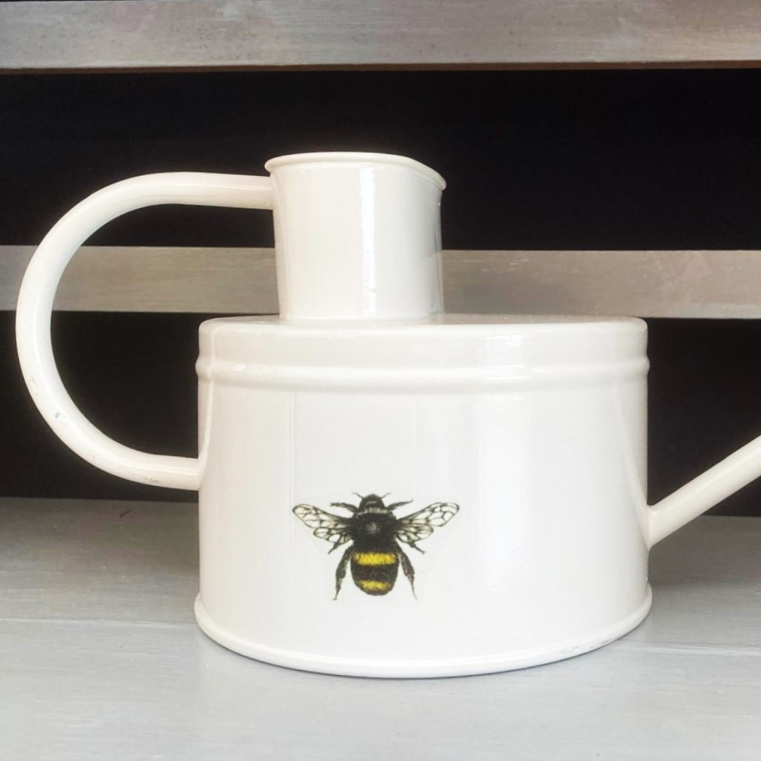 watering can with cream paint and bee motif
